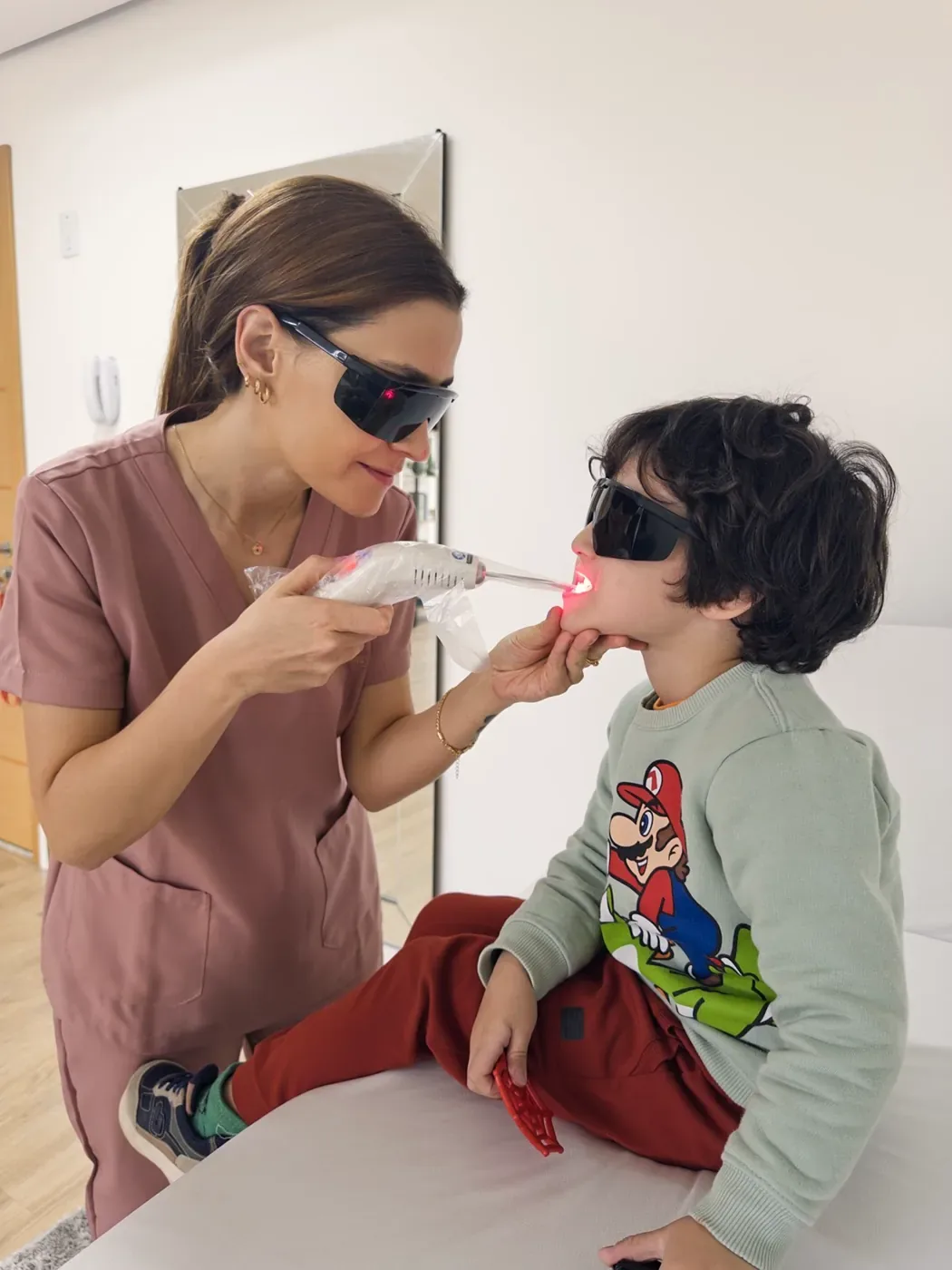 Laser para dor da dentição infantil em Porto Alegre, com a criança protegida por óculos