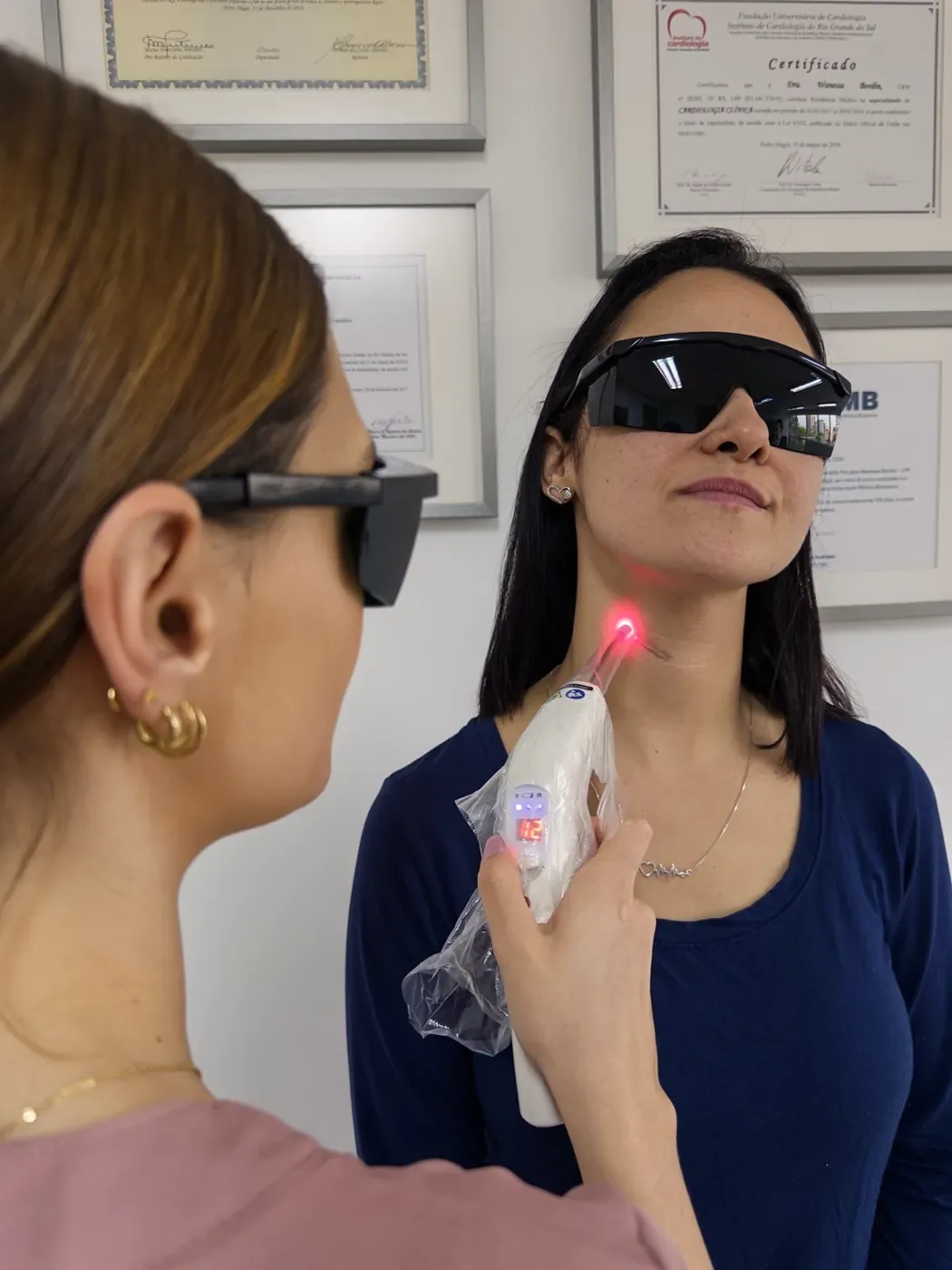 Enfermeira da Dualume aplicando laserterapia em cicatriz em Porto Alegre, com paciente de óculos de proteção