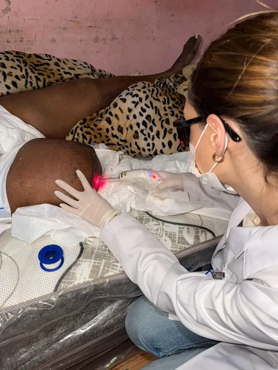 Enfermeira da Dualume aplicando laserterapia no pós-operatório, em atendimento domiciliar em Porto Alegre